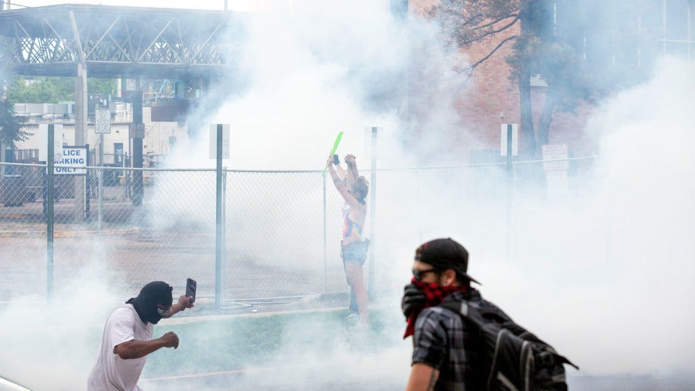 Officers covered a crowd surrounding Denver Police District Six's headquarters with tear gas on the third day of protests in reaction to the killing of George Floyd. May 30, 2020. (Kevin J. Beaty/Denverite)
