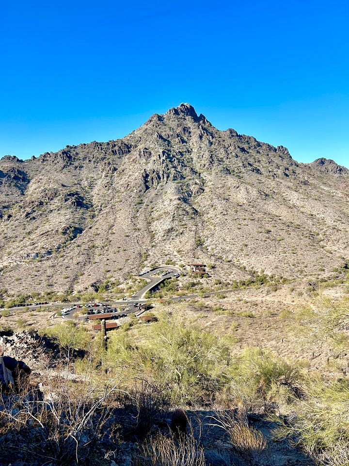 A photo of Adrianna's feet in athletic shoes at the top of a mountain; a photo of the mountain from the ground.