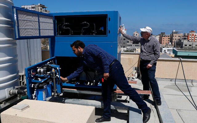 In this April 30, 2020, photo, Palestinian engineer Raed Nakhal from Palestine Children Relief Fund, right, and engineer Abdullah Dewik, check the GEN-M machine that generates safe drinking water from air at the roof of al-Rantisi pediatric hospital in Gaza City. (AP Photo/Adel Hana) In this April 30, 2020, photo, Palestinian engineer Raed Nakhal from Palestine Children Relief Fund, right, and engineer Abdullah Dewik, check the GEN-M machine that generates safe drinking water from air at the roof of al-Rantisi pediatric hospital in Gaza City. (AP Photo/Adel Hana)