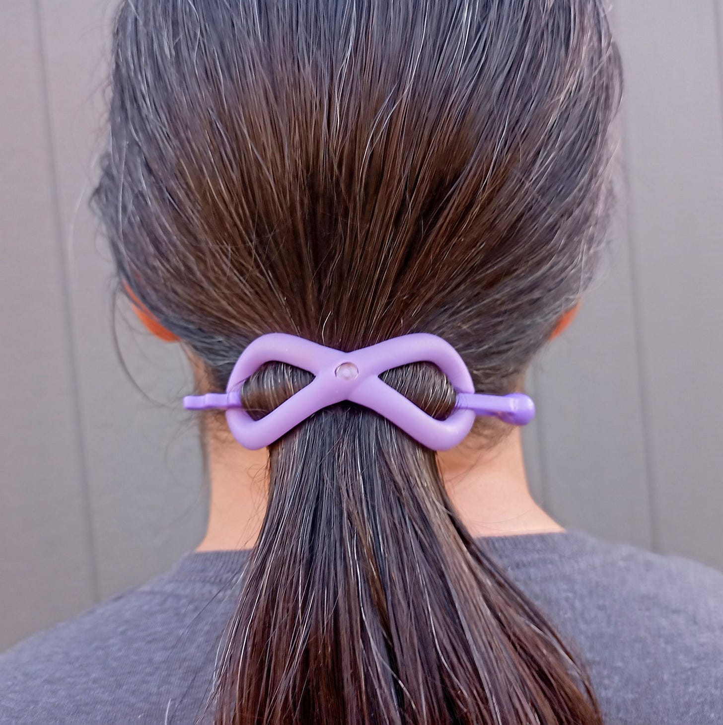 Woman with long brown hair with purple Flexi hair clip in ponytail