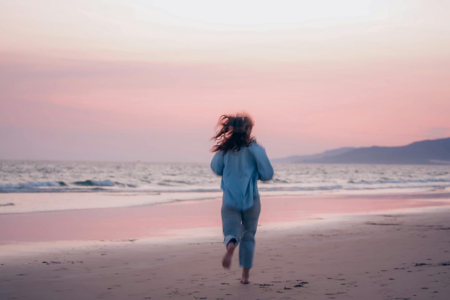 woman running on a beach in sunset
