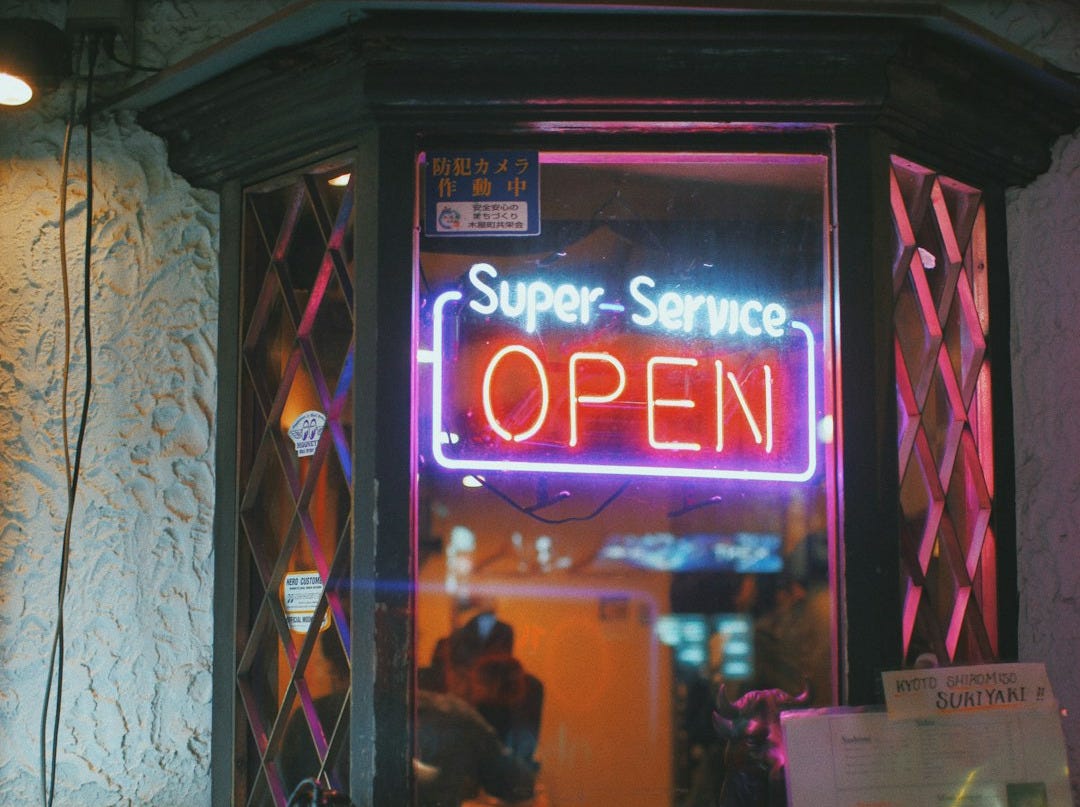 Super-Service open neon signage hanged on window