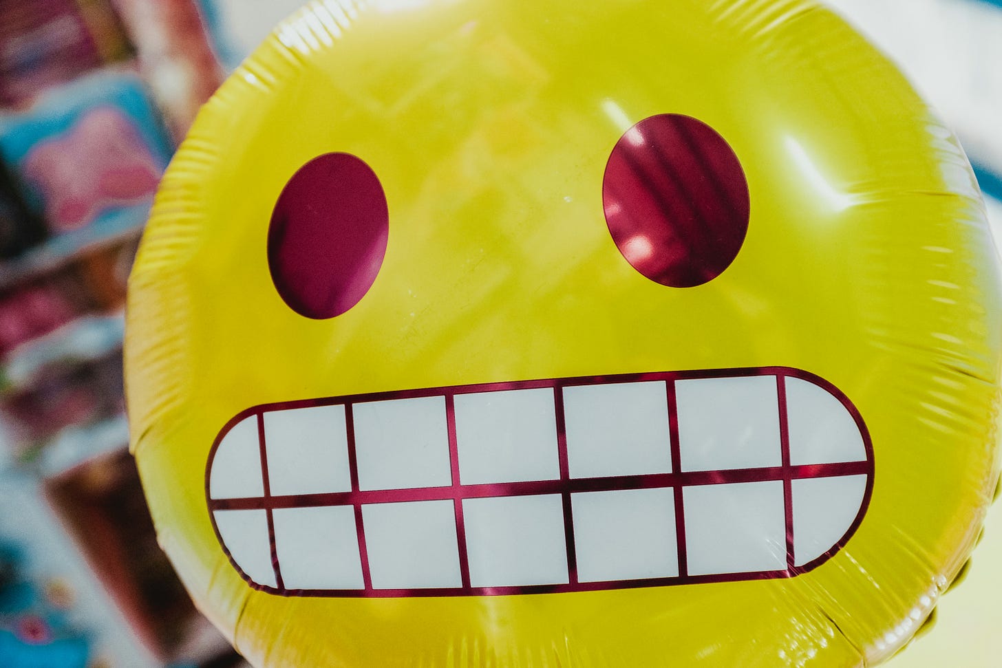 a large inflatable emoji with a grimacing expression a large inflatable emoji with a grimacing expression