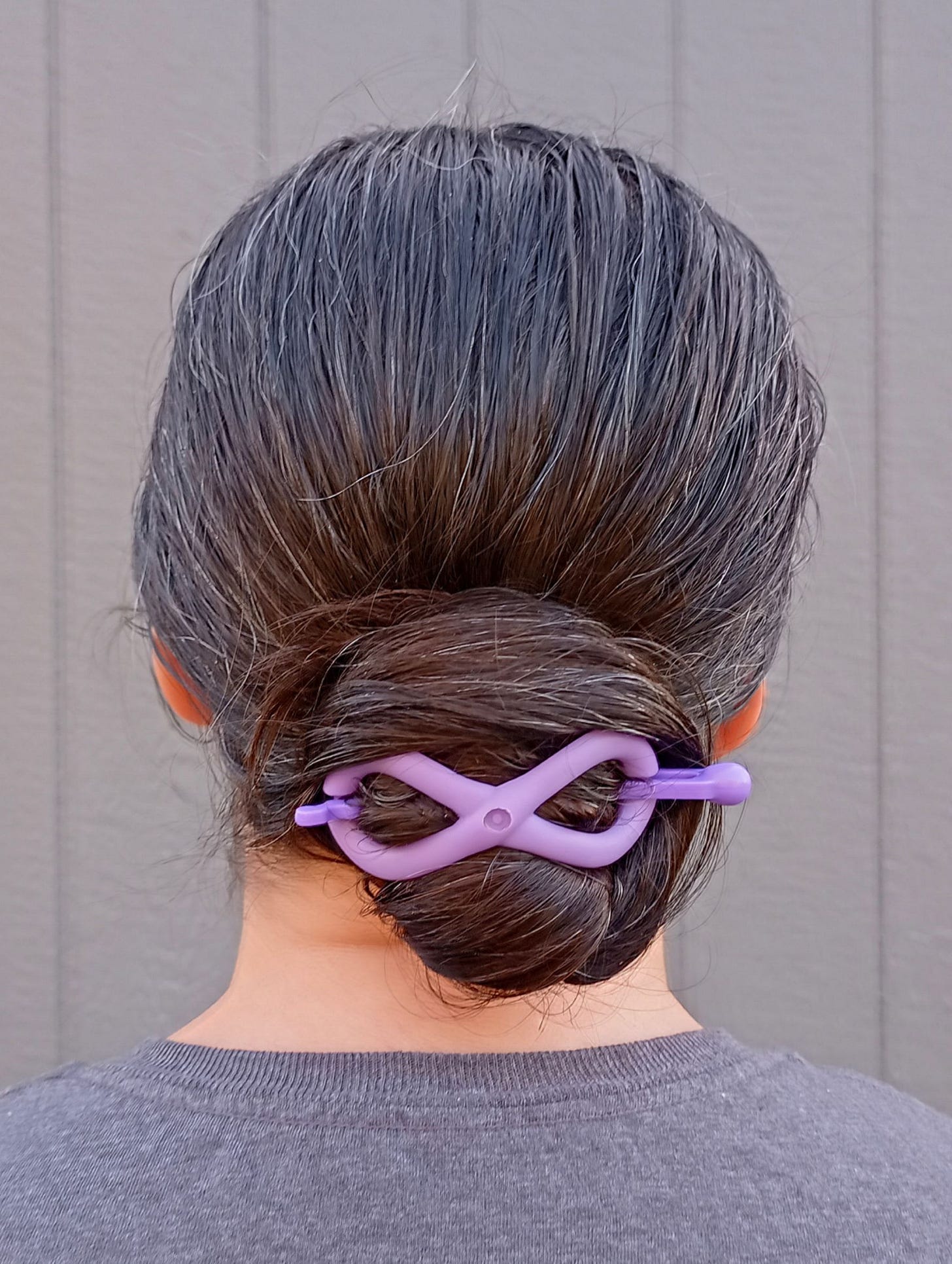 Woman with long brown hair in Nautilus bun with purple Flexi hair clip