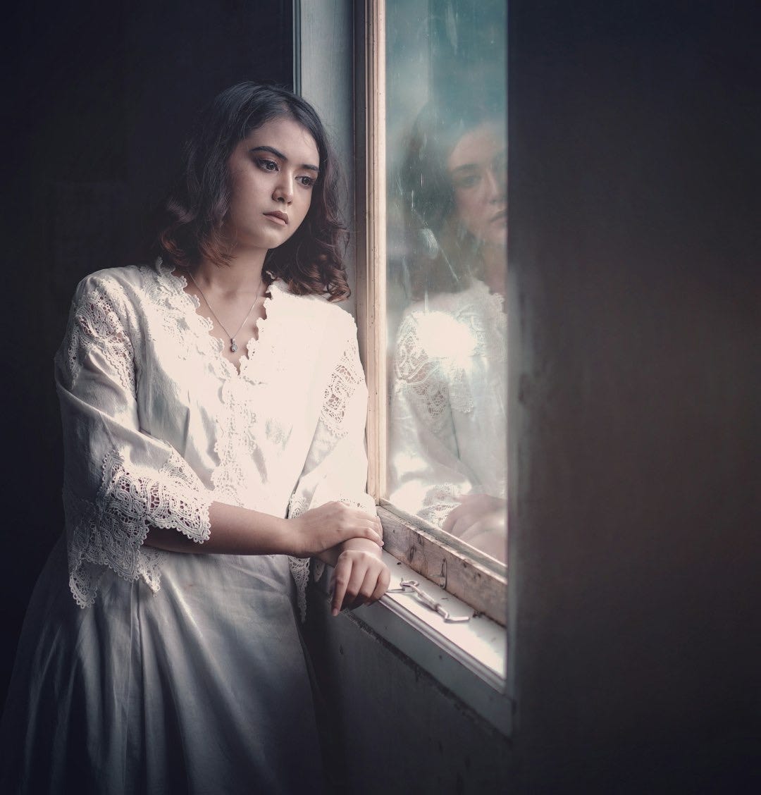 a woman is looking out of a window a woman is looking out of a window