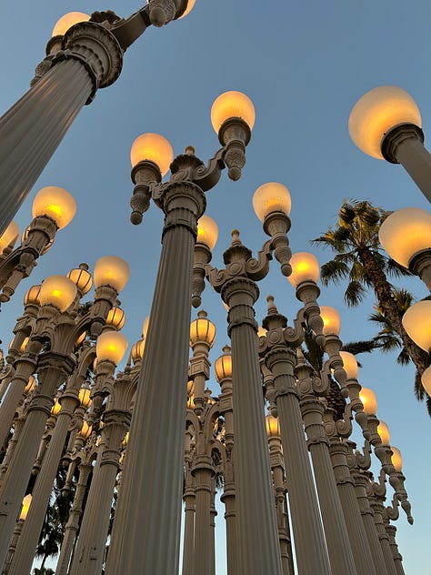 Urban Lights at sunset, Mark Bradford’s 150 Portrait Tone, a mural across a wall with Blank Panthers in it, lunch on a table outside, fluorescent lightblubs on their side on the wall, Magritte's The Treachery of Images, and a painting by Diego Rivera.