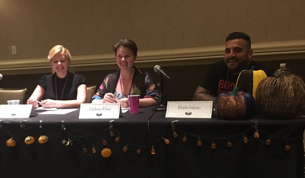 Three authors sitting at a long table