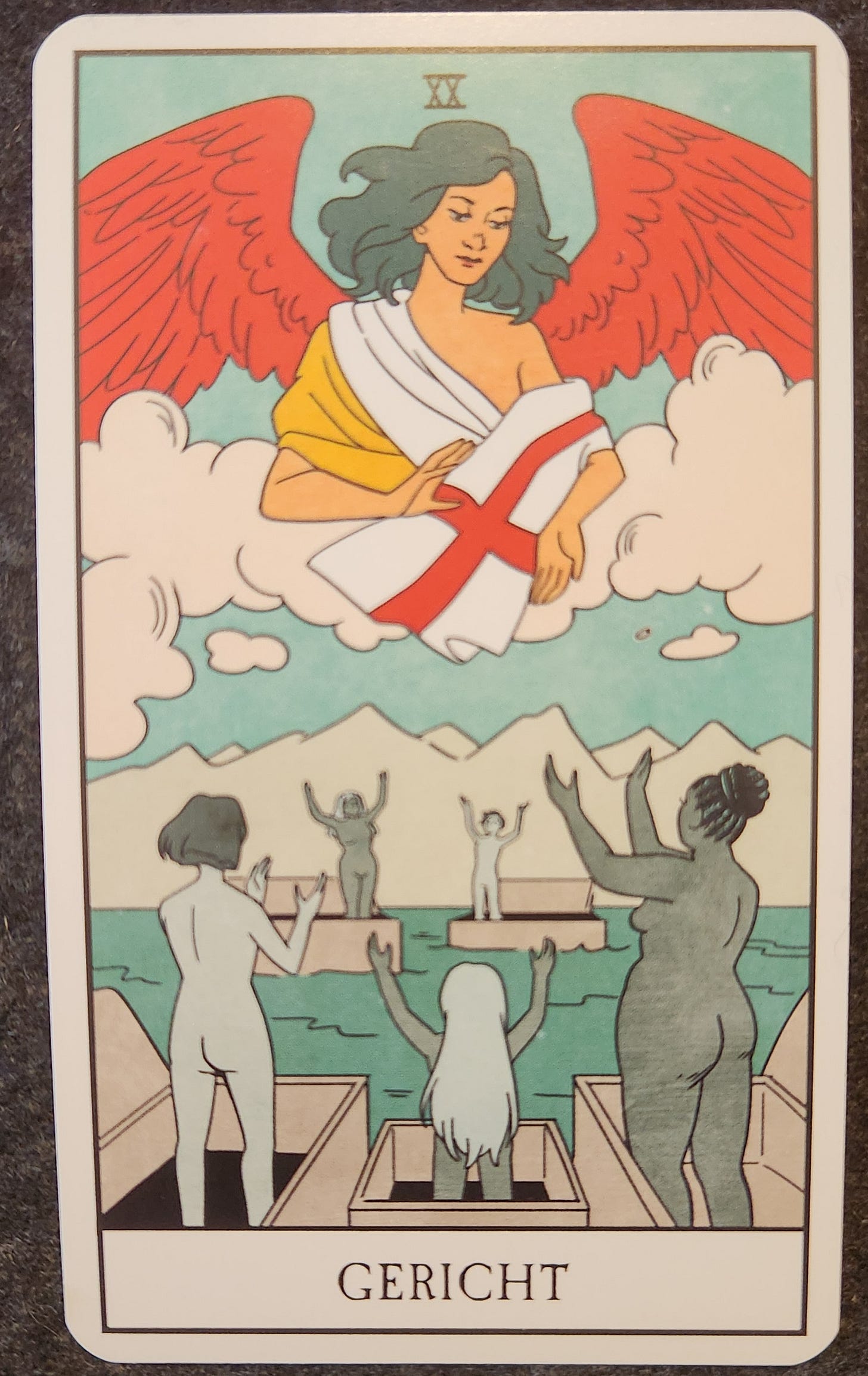 A tarot card labelled XX Gericht. A number of naked people, each standing in a coffin floating on the ocean. They are standing with their arms upraised. In the sky, is an angel with red wings looking down at them. The angel is holding a flag that resembles the English flag. 