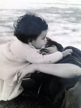 A mother hugs her young daughter.