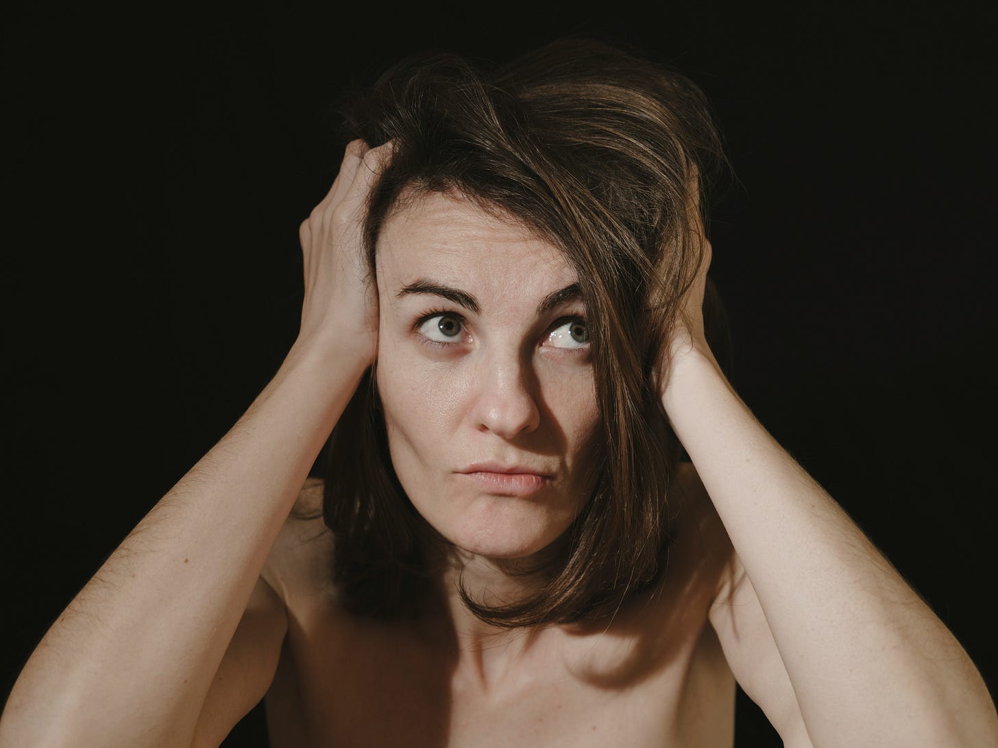 a woman holding her head in her hands a woman holding her head in her hands