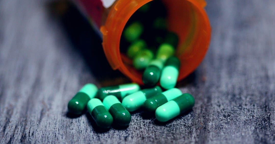 shallow focus photography of prescription bottle with capsules shallow focus photography of prescription bottle with capsules