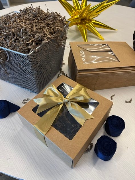 Images show Weapon S and J necklaces plus a gift wrapped box