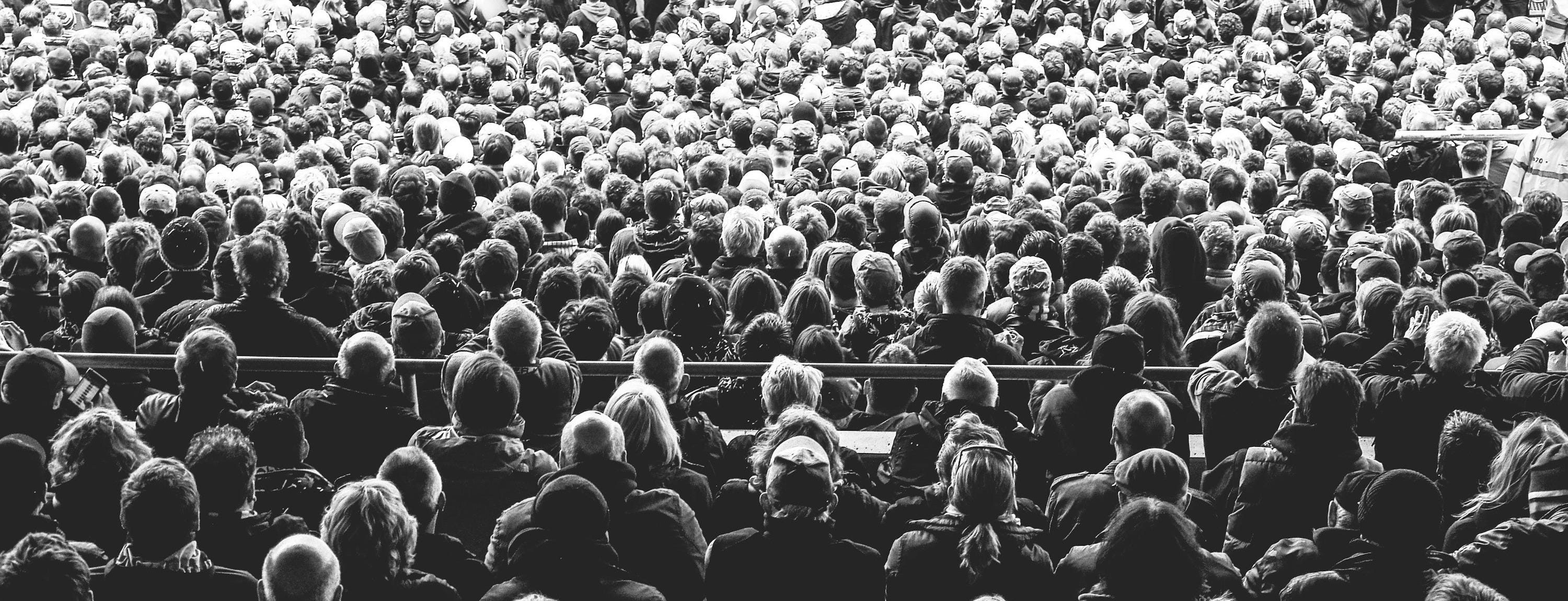 grayscale photo of people sitting on chair