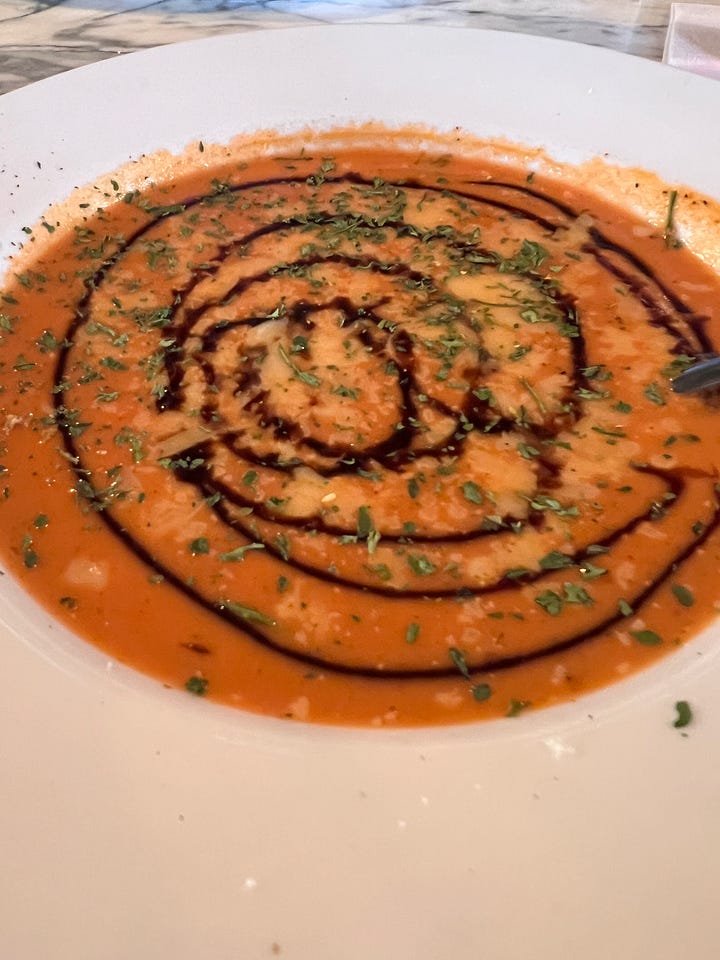 tomato bisque with balsomic drizzle and a plate of croutons