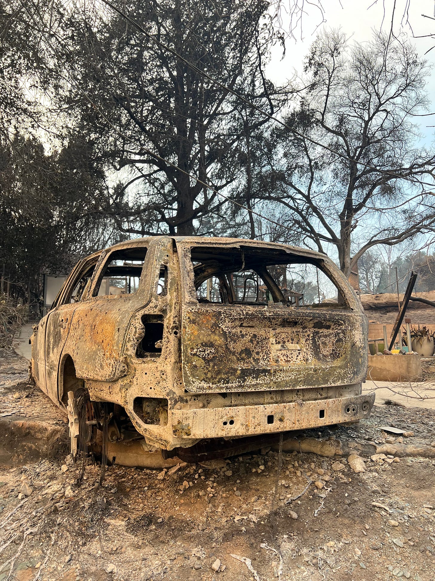 a burned car sitting among rubble
