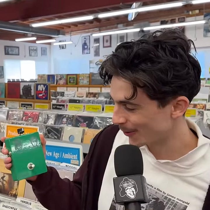 Nardwuar offre à Timothée Chalamet une pédale de guitare à leur effigie.