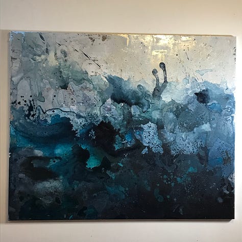 Some paintings as works in progress, with swirls of blue, green and silver.