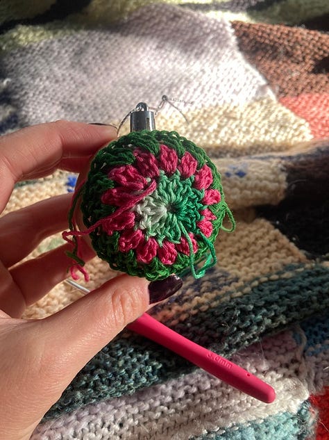 Messy heap of yarns and crochet hooks, a crochet Christmas bauble in Wicked colours (pink and green), my first crochet granny square
