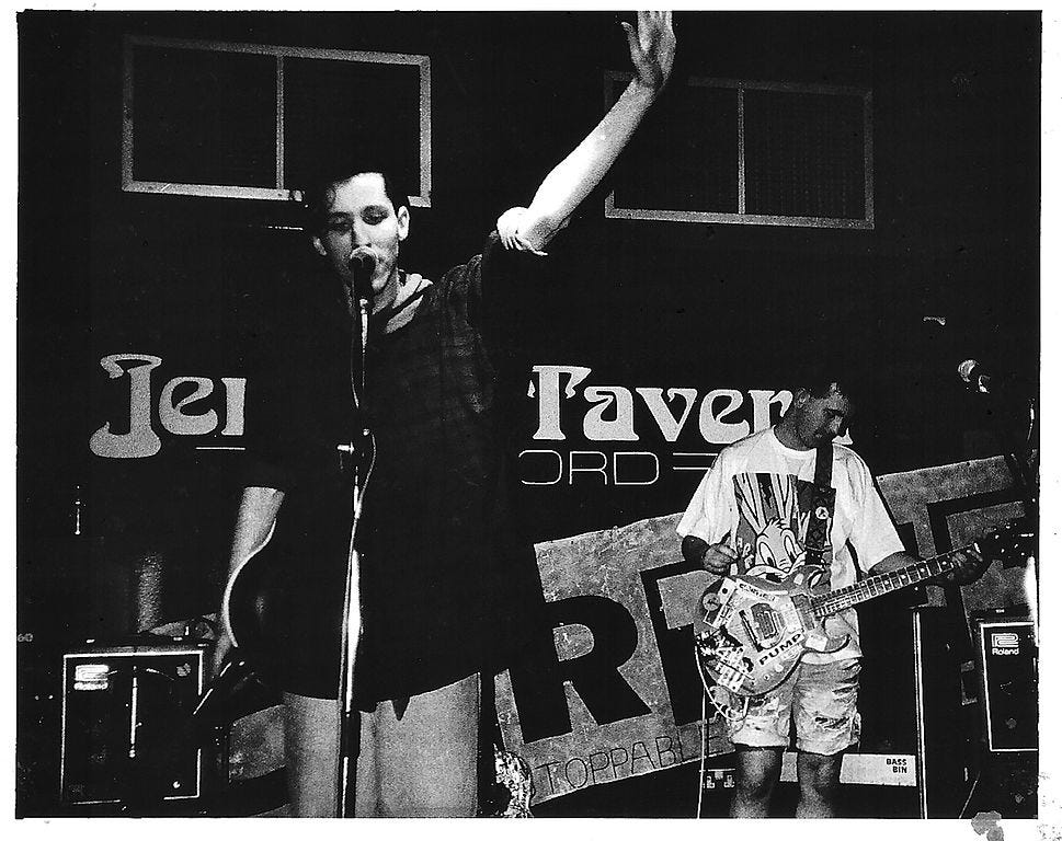Black and white photo of a singer and guitarist on a small stage. Black and white photo of a singer and guitarist on a small stage.