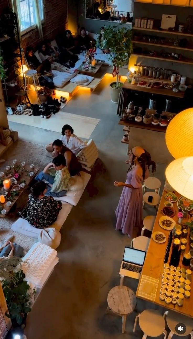 This may contain: an overhead view of people sitting on couches in a living room with many tables and chairs