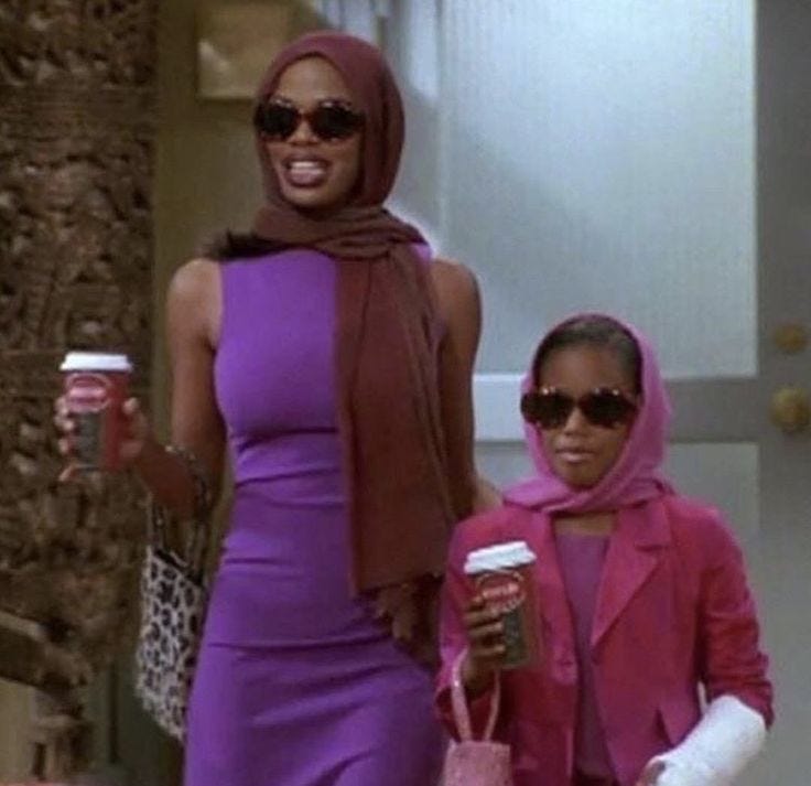 This may contain: two women walking down the street with coffee in their hands and one holding a pink purse