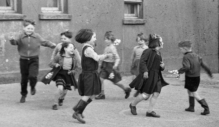This may contain: black and white photograph of children playing outside
