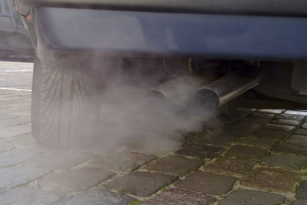A car’s tailpipe emitting exhaust fumes. Vehicle emissions contain pollutants like nitrogen oxides, particulate matter, and toxic chemicals that contribute to smog and harm human health.