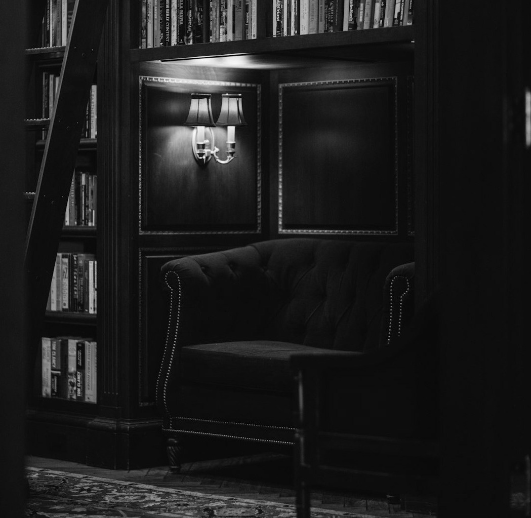 a green couch sitting in front of a bookshelf filled with books a green couch sitting in front of a bookshelf filled with books