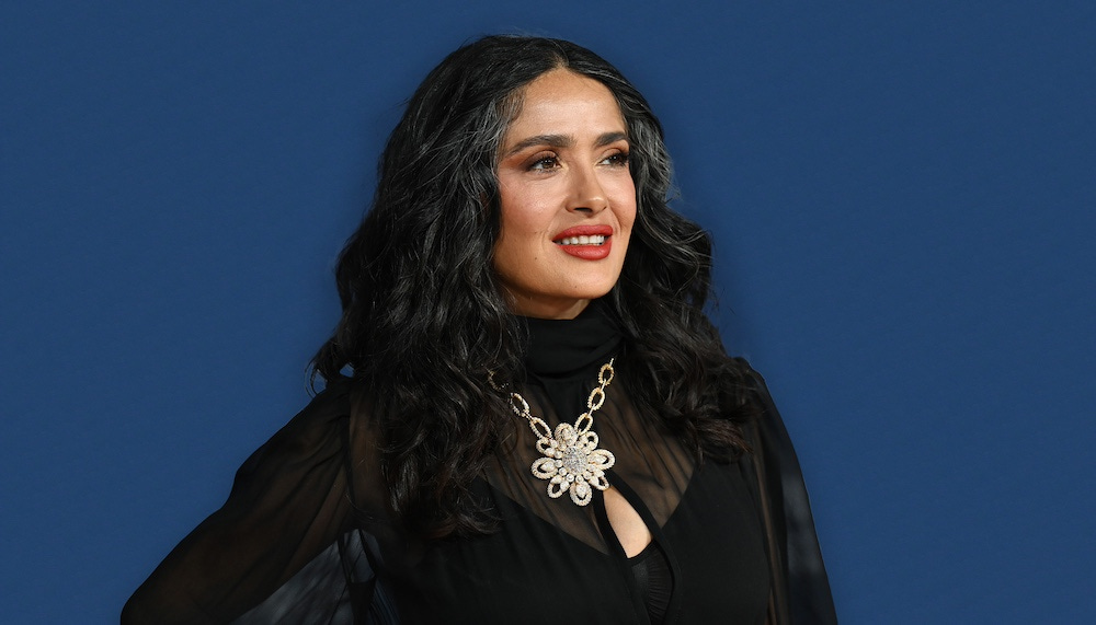 salma hayek pinault in front of a blue background