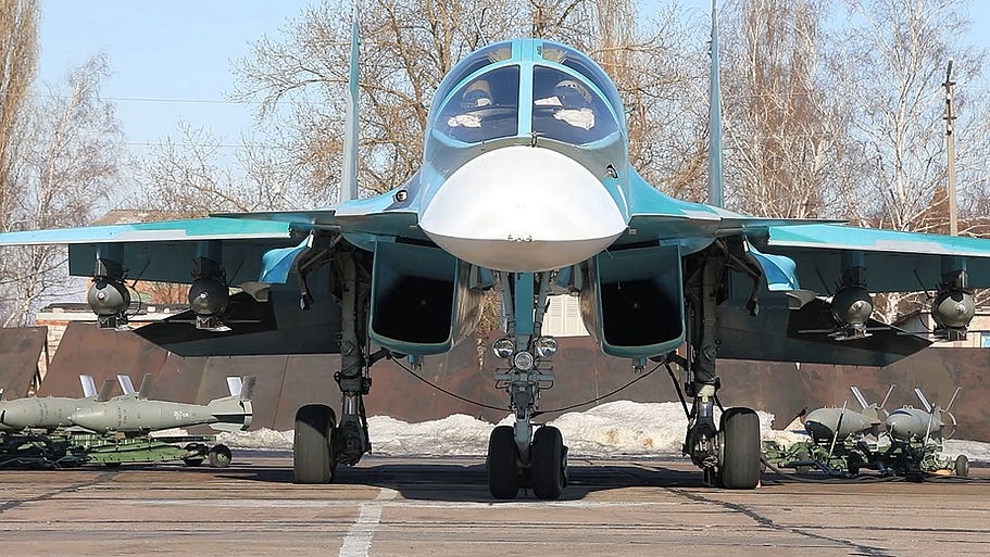 A Su-34 loaded with four UMPK guided glide bombs with additional UMPK bombs in the background A Su-34 loaded with four UMPK guided glide bombs with additional UMPK bombs in the background