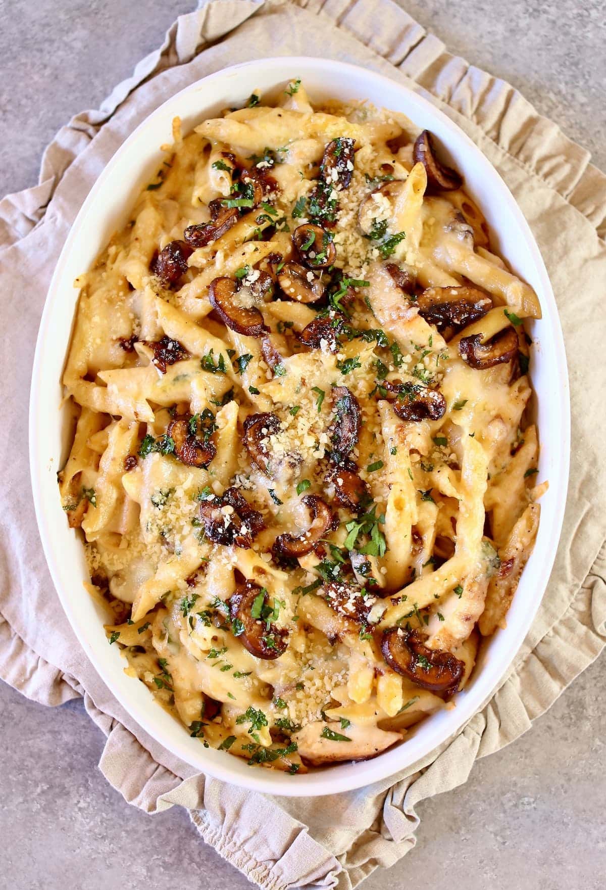 a white platter with chicken pasta.