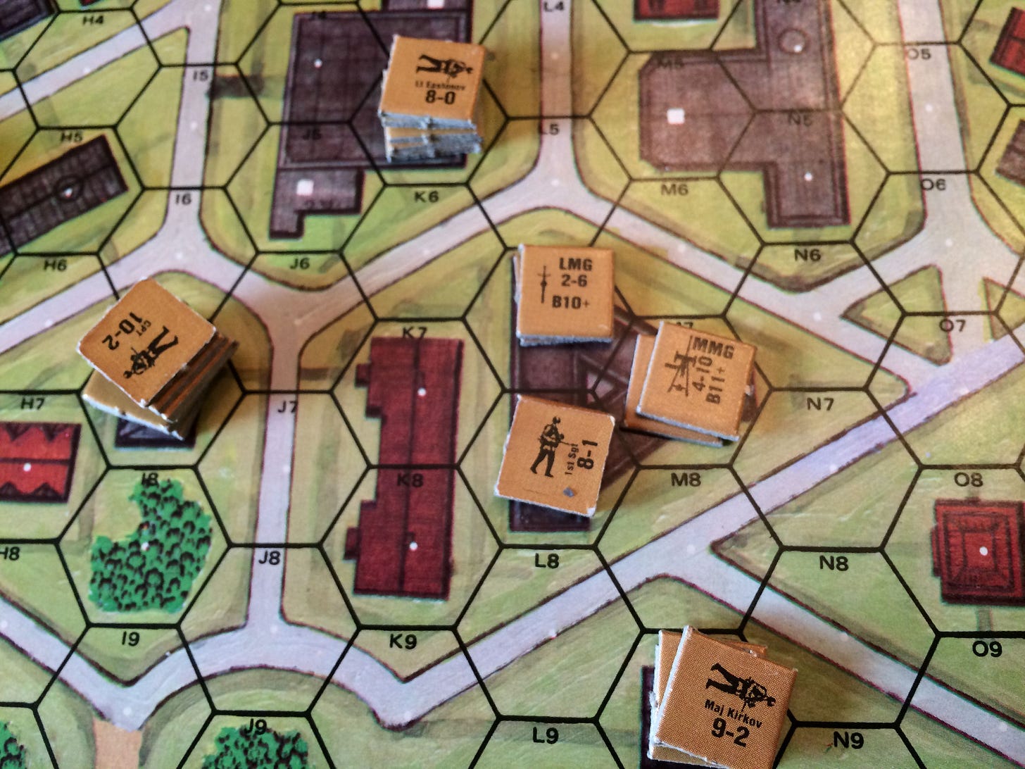 A hex grid showing buldings with chits representing men and machine guns in several buildings. A hex grid showing buldings with chits representing men and machine guns in several buildings.