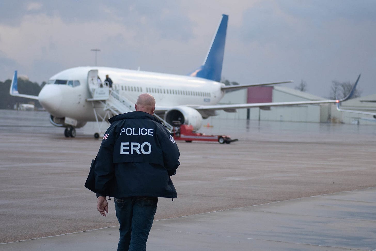 An ICE Enforcement & Removal Operations (ERO) Officer approaches an ICE deportation flight (Immigration & Customs Enforcement photo) An ICE Enforcement & Removal Operations (ERO) Officer approaches an ICE deportation flight (Immigration & Customs Enforcement photo)