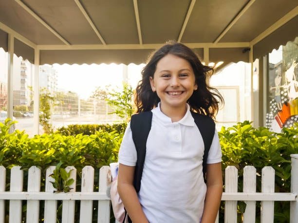 Portrait of a young student girl smiling outside the school Portrait of a young student girl smiling outside the school girl-8-years-old stock pictures, royalty-free photos & images