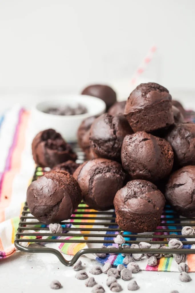 a pile of small chocolate muffins on a cooling rack