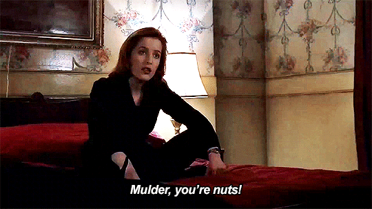 Sitting cross-legged still in her pantsuit on her hotel bed, Scully says "Mulder, you're nuts!" Sitting cross-legged still in her pantsuit on her hotel bed, Scully says "Mulder, you're nuts!"