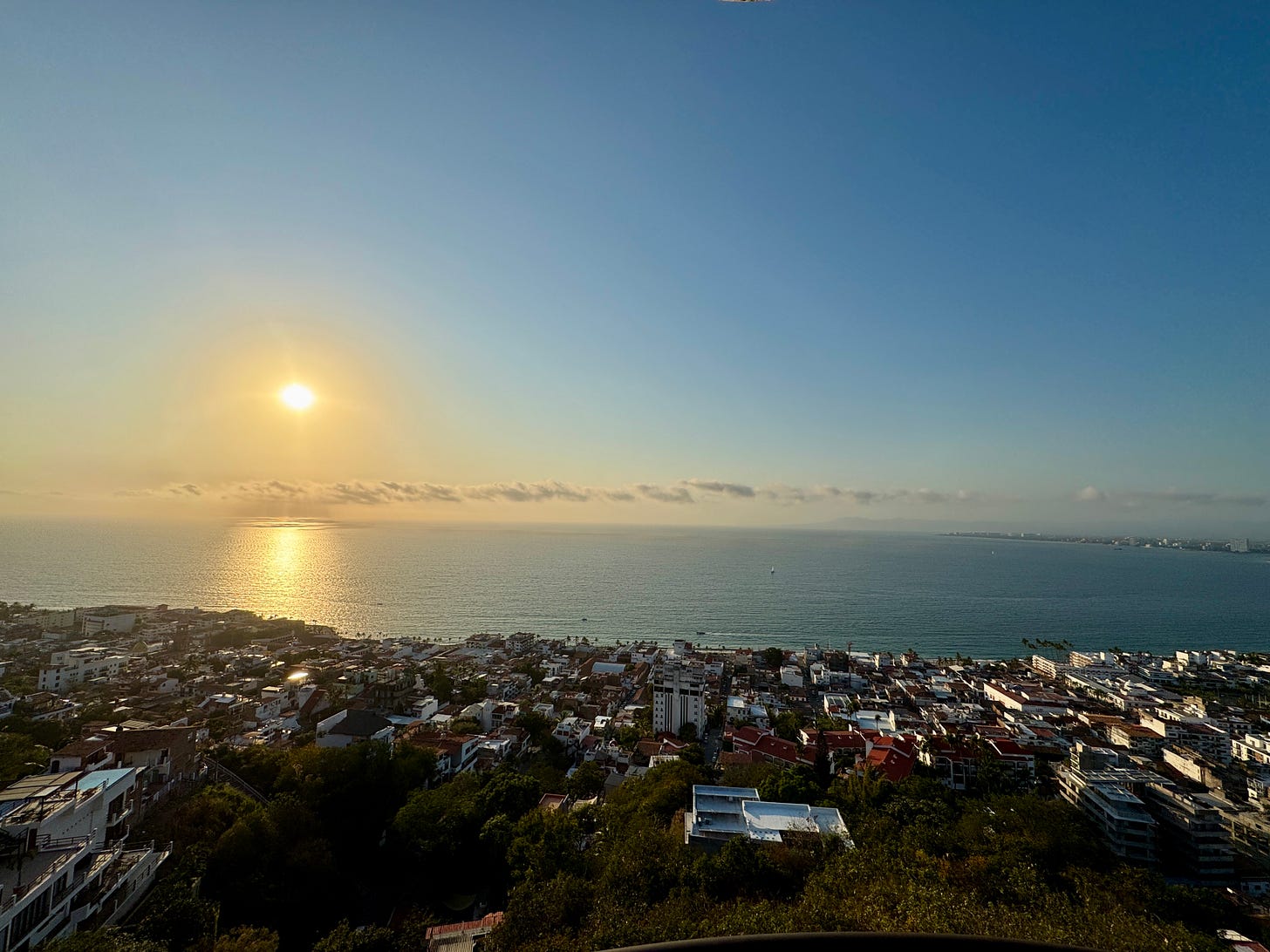 The sun setting over the ocean and Puerto Vallarta The sun setting over the ocean and Puerto Vallarta