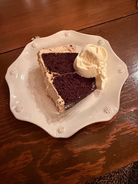 A slice of cake on a plate, frosting a cake, a cake on a plate outdoors