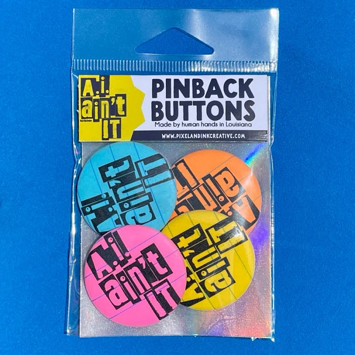 First photo: hand printed pocket sized notebooks. Second photo: Pinback buttons in bright colors that say, "A.I. ain't it."