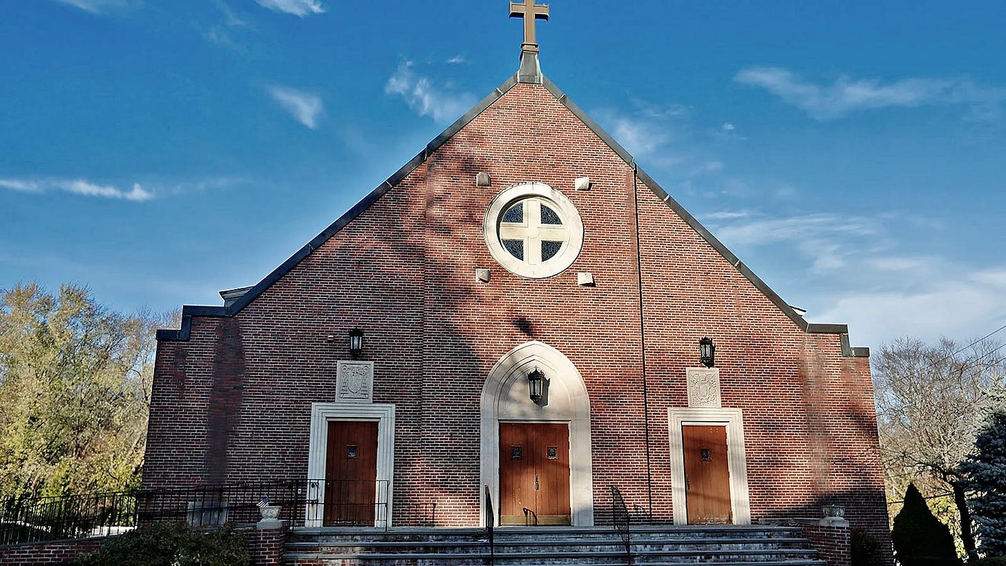 A brick church with a cross on top and blue sky. A brick church with a cross on top and blue sky.