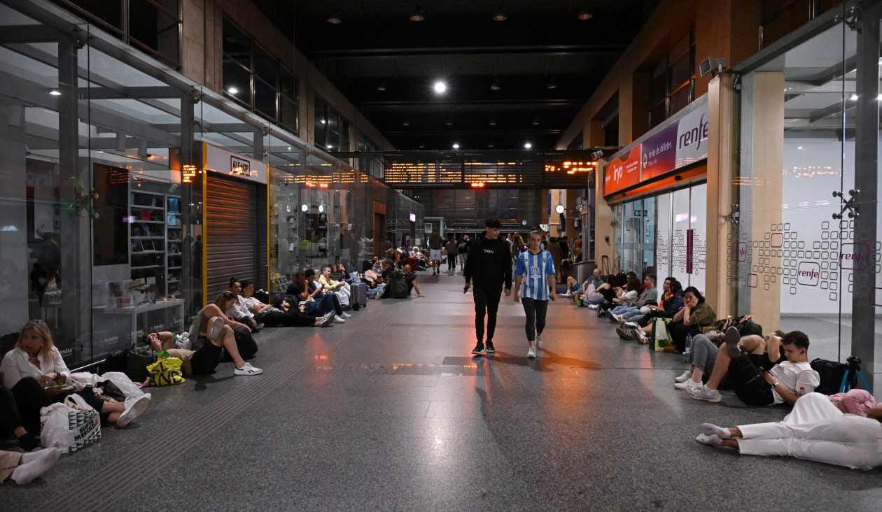 Travelers prepare to spend the night at a train station in Spain during a massive power outage across the Iberian Peninsula and the south of France.