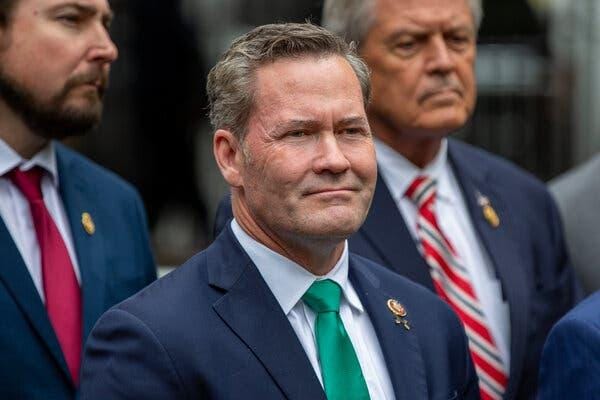 Representative Michael Waltz wearing a dark suit and green tie. Representative Michael Waltz wearing a dark suit and green tie.