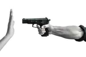 Hand saying No to another hand pointing gun