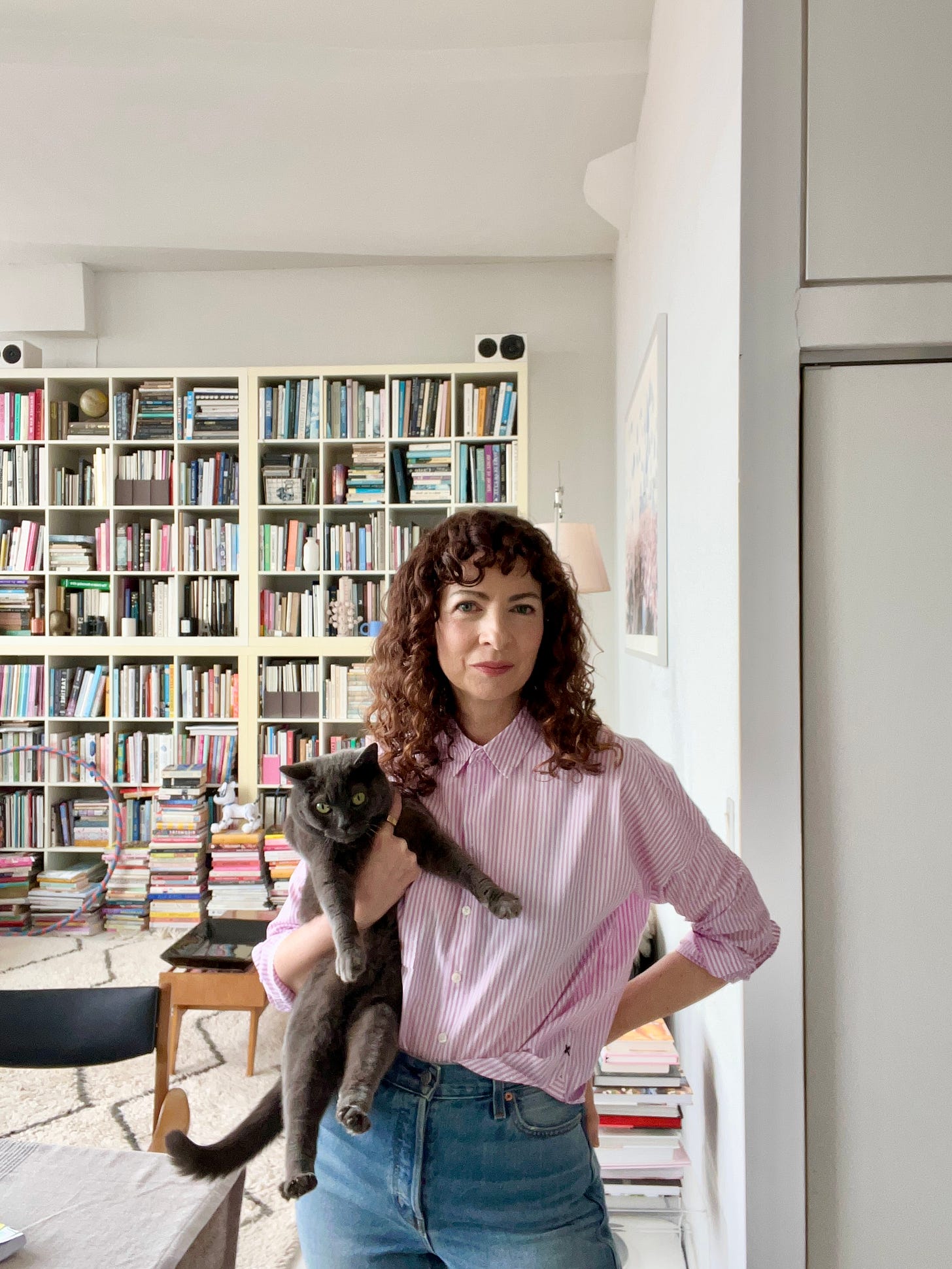 Kerry Diamond and Dusty in front of their cookbook shelves