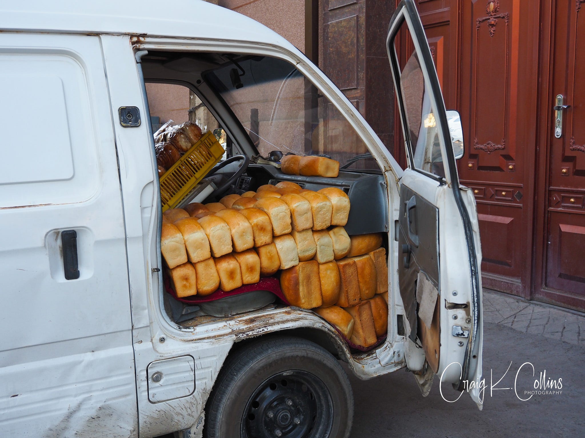 A white van is stuffed with hundreds of loaves of fresh-baked bread.