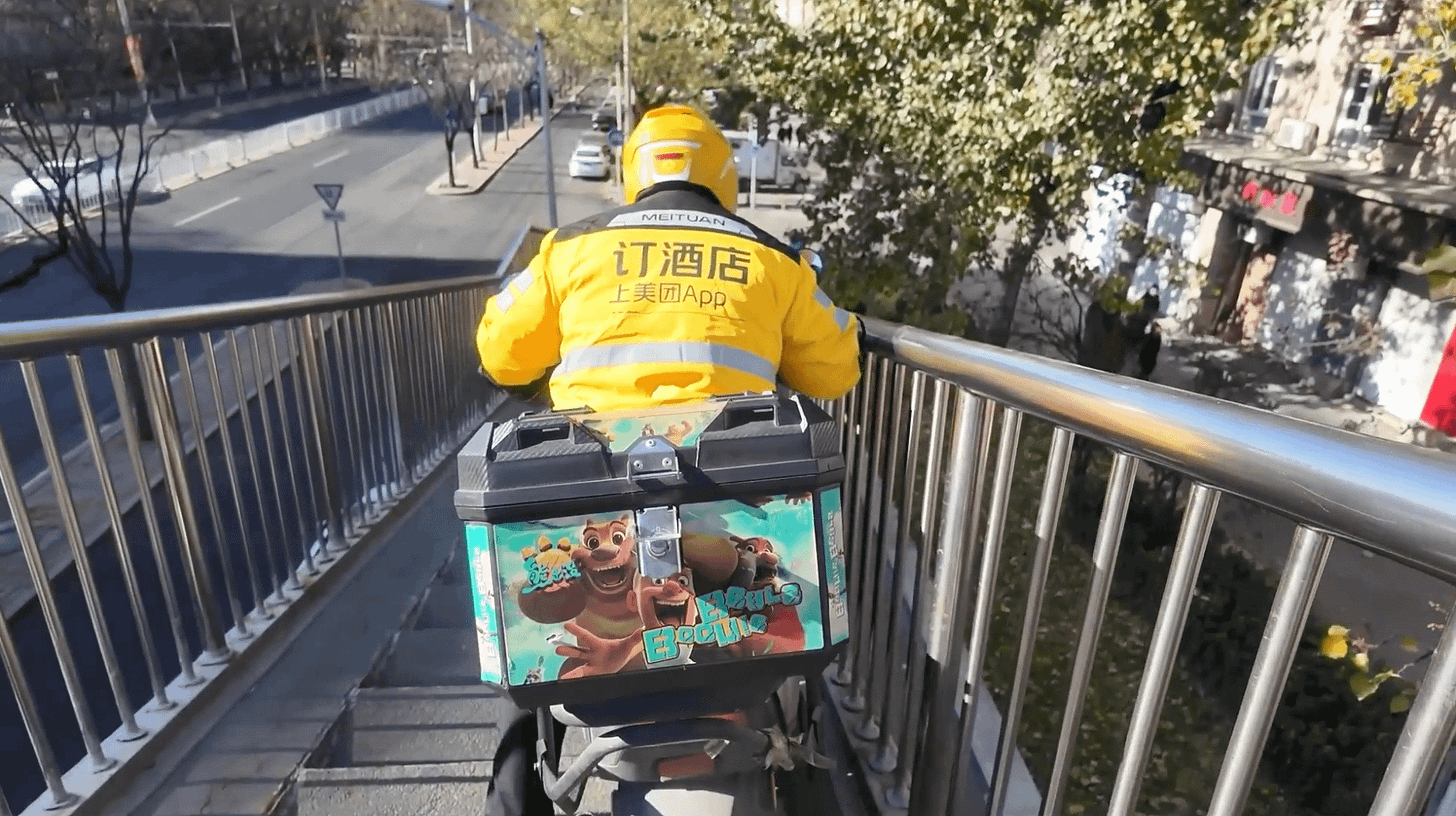 美团一名外送骑手穿行北京一座过街天桥。 美团一名外送骑手穿行北京一座过街天桥。