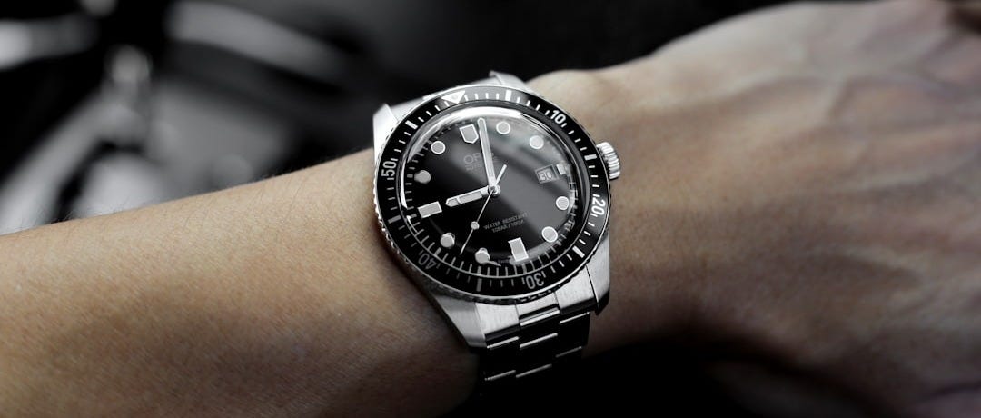 person hand with silver-colored watch