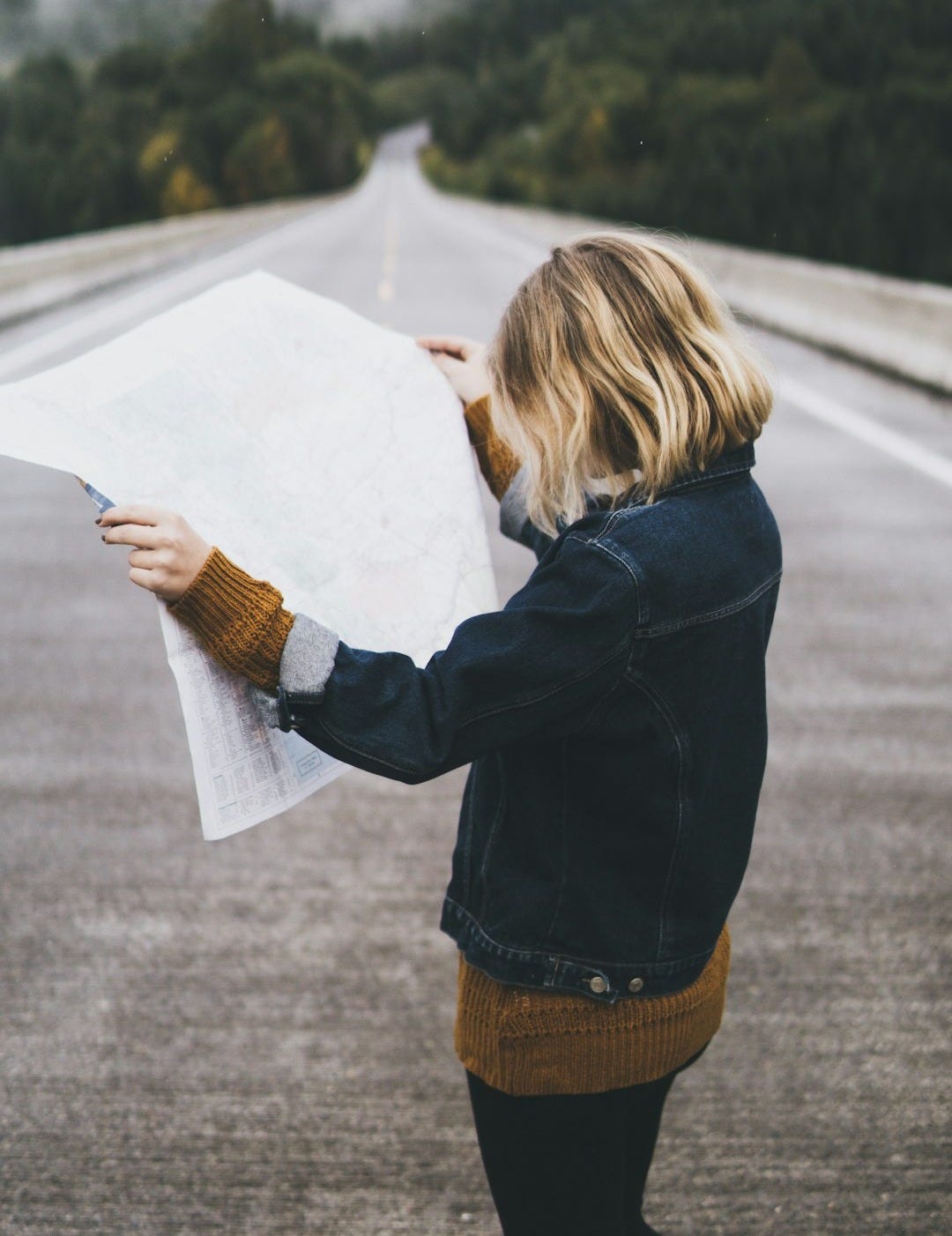 woman looking at map while standing on road woman looking at map while standing on road