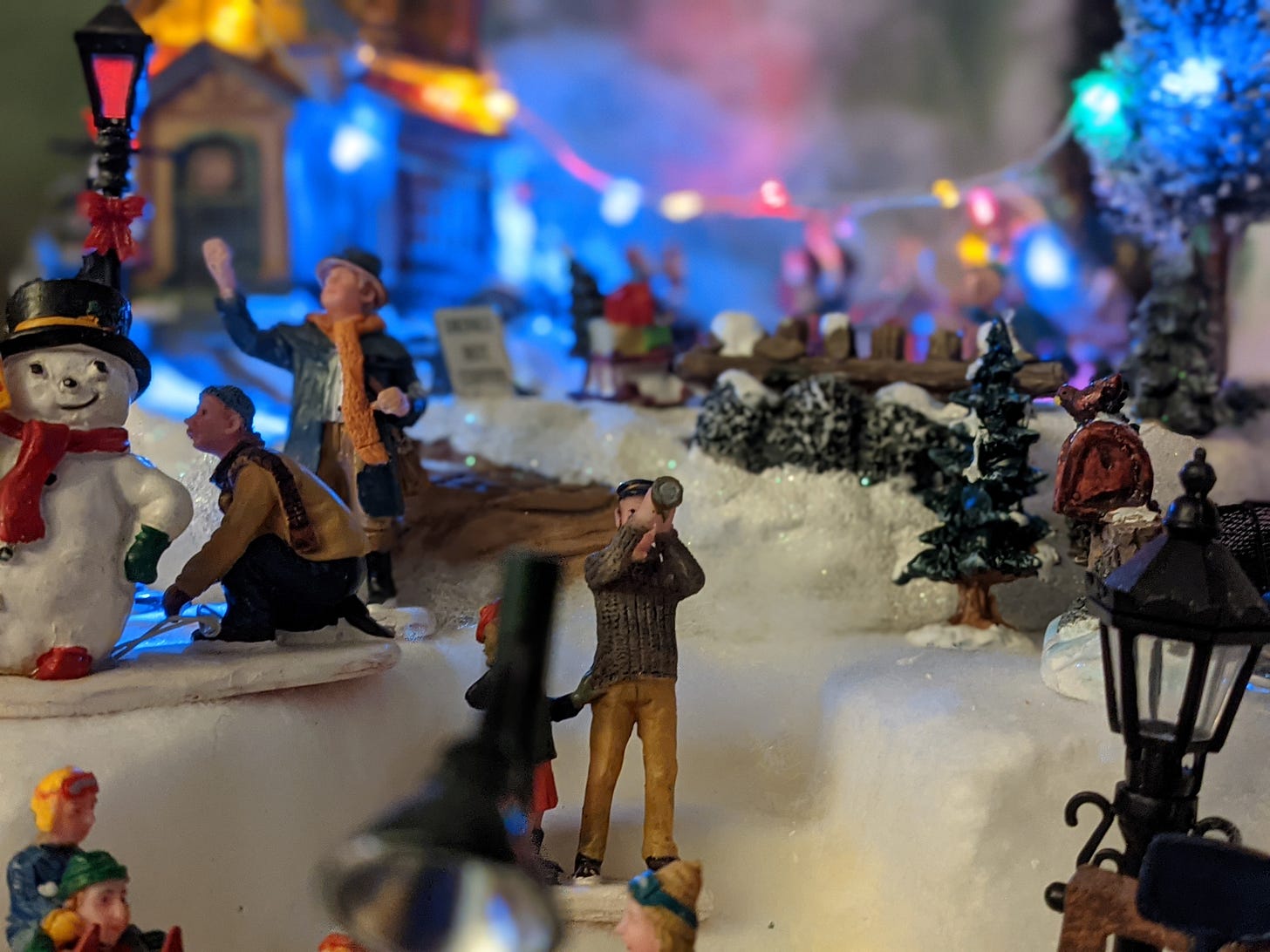 Photo of a miniature ceramic man looking through a telescope at the sky