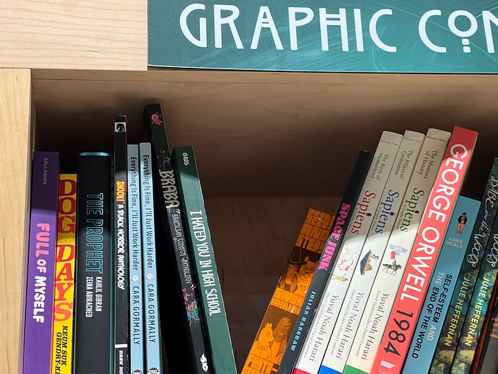 The author with their mouth agape in wonder and delight at their book in the wild in a bookstore; their book on a shelf